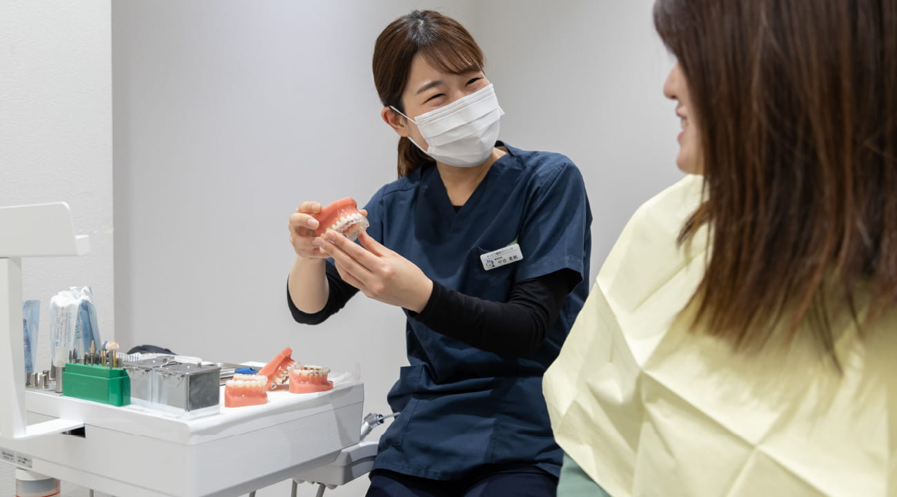 患者さんからの質問を受ける女性の歯科医