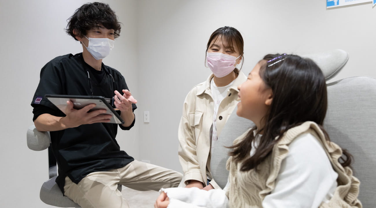 優しそうな歯科医の話を聞くお母さんと子供